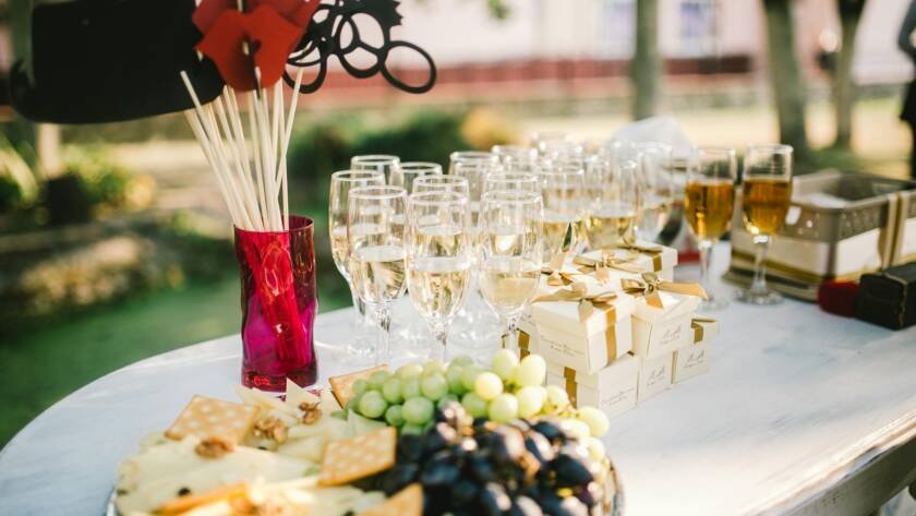 champagne glasses gift boxes and cheese grape and crackers on tray