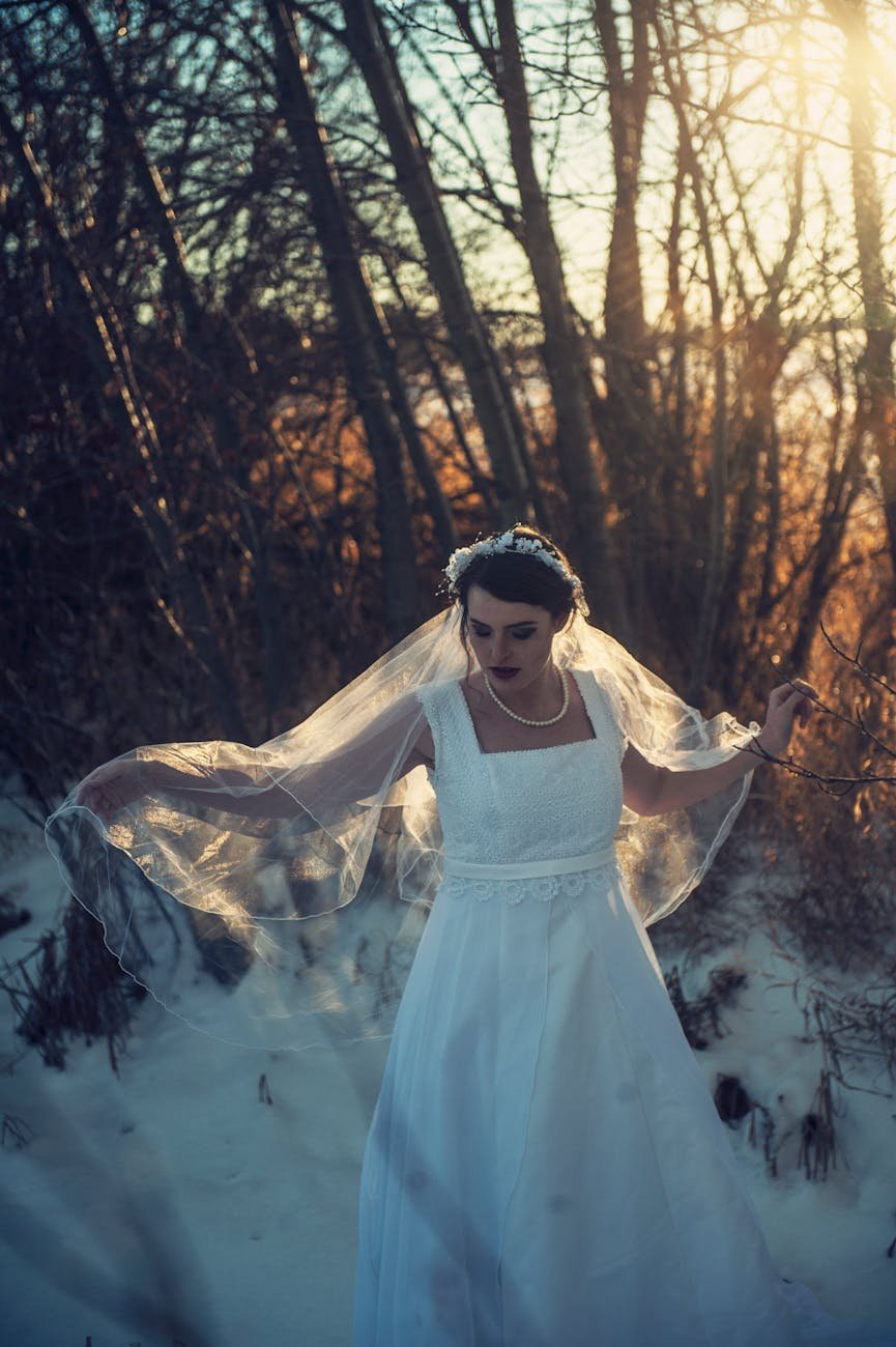 woman wearing wedding dress walking near trees