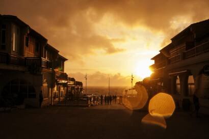 people standing near posts during orange sunset