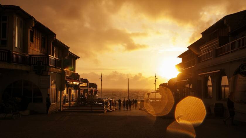 people standing near posts during orange sunset