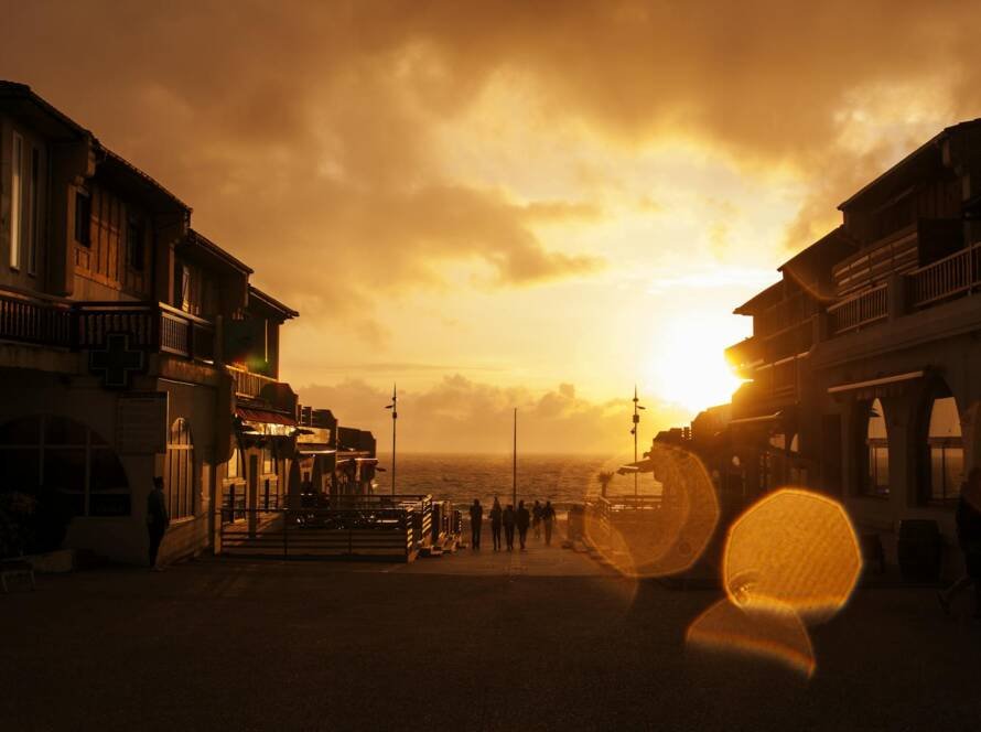 people standing near posts during orange sunset