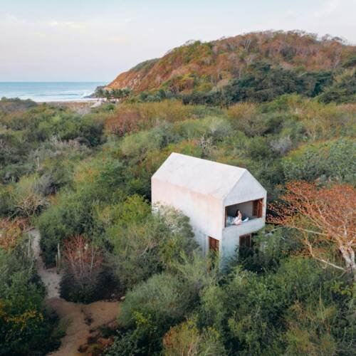 white wooden house on green grass field near body of water