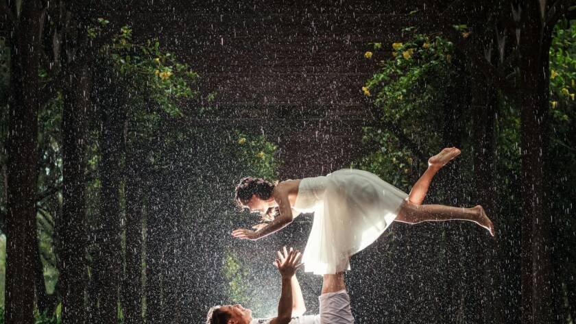 bride and groom doing a photoshoot in the rain
