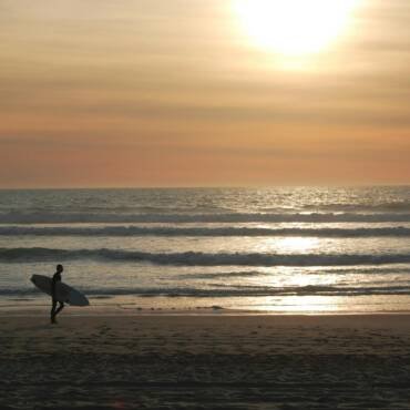 surfer on beach at dawn