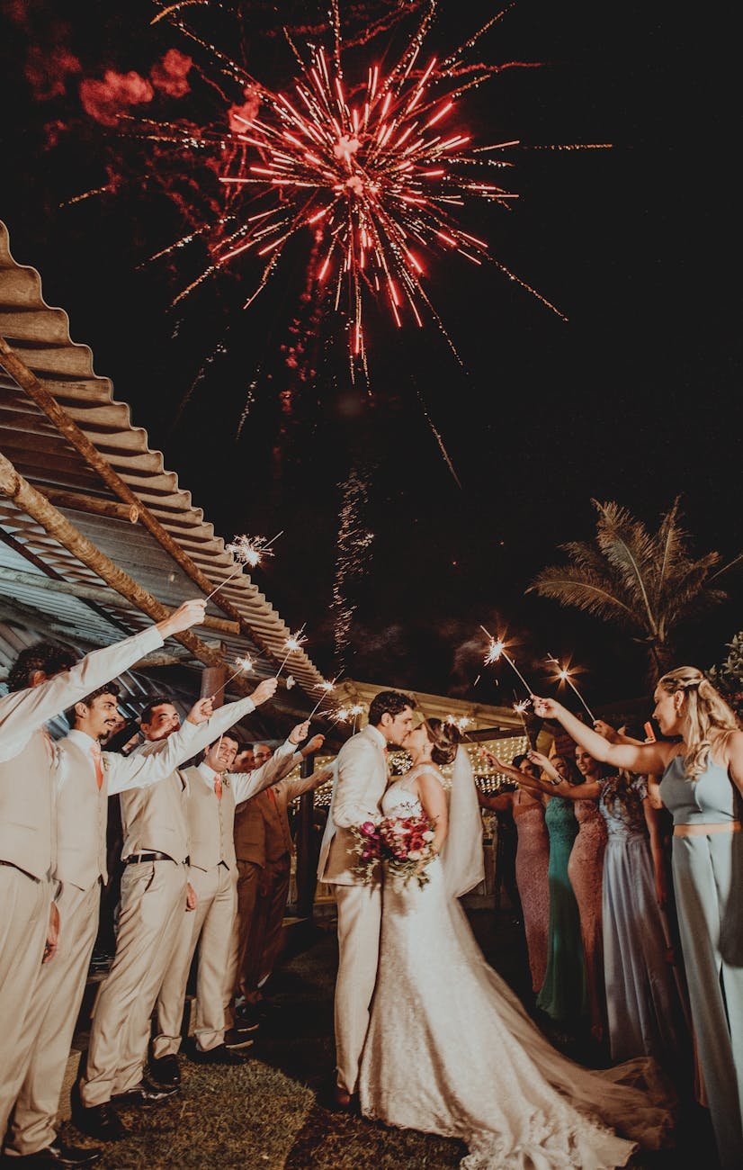 red fireworks above wedding couple