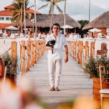 a man holding a camera while standing on the wooden boardwalk