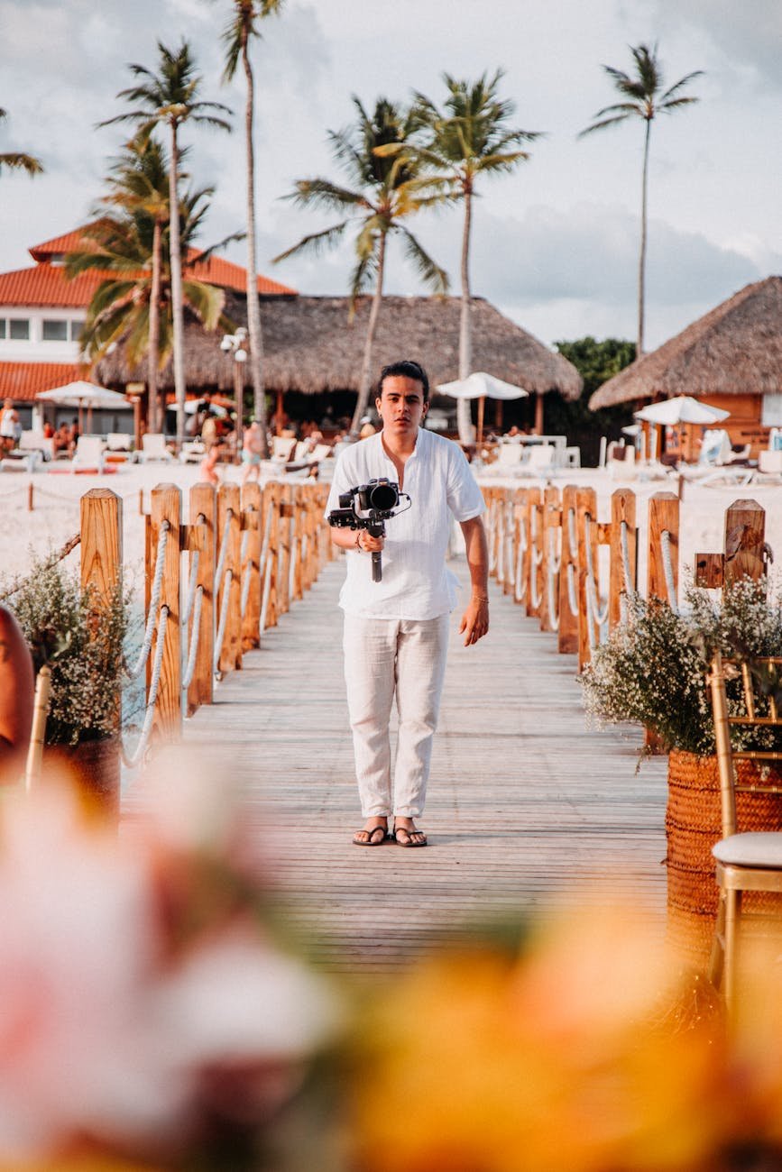 a man holding a camera while standing on the wooden boardwalk